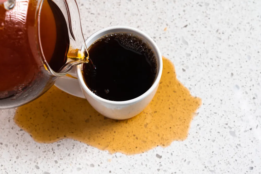 Coffee Spill Overflowing mug of coffee on with granite countertop