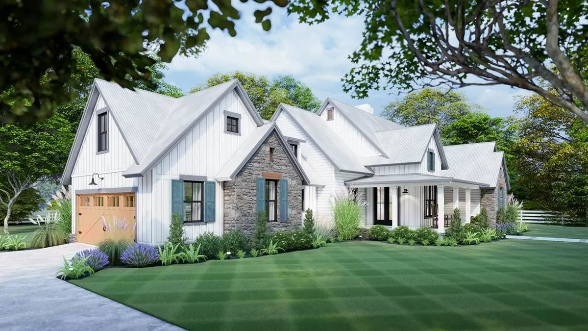 A wide yard is seen in the front as well as the garage area with a wooden entrance.