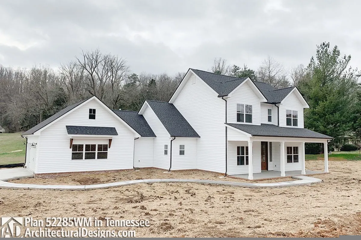 Modern farmhouse with a walkway through the garage.
