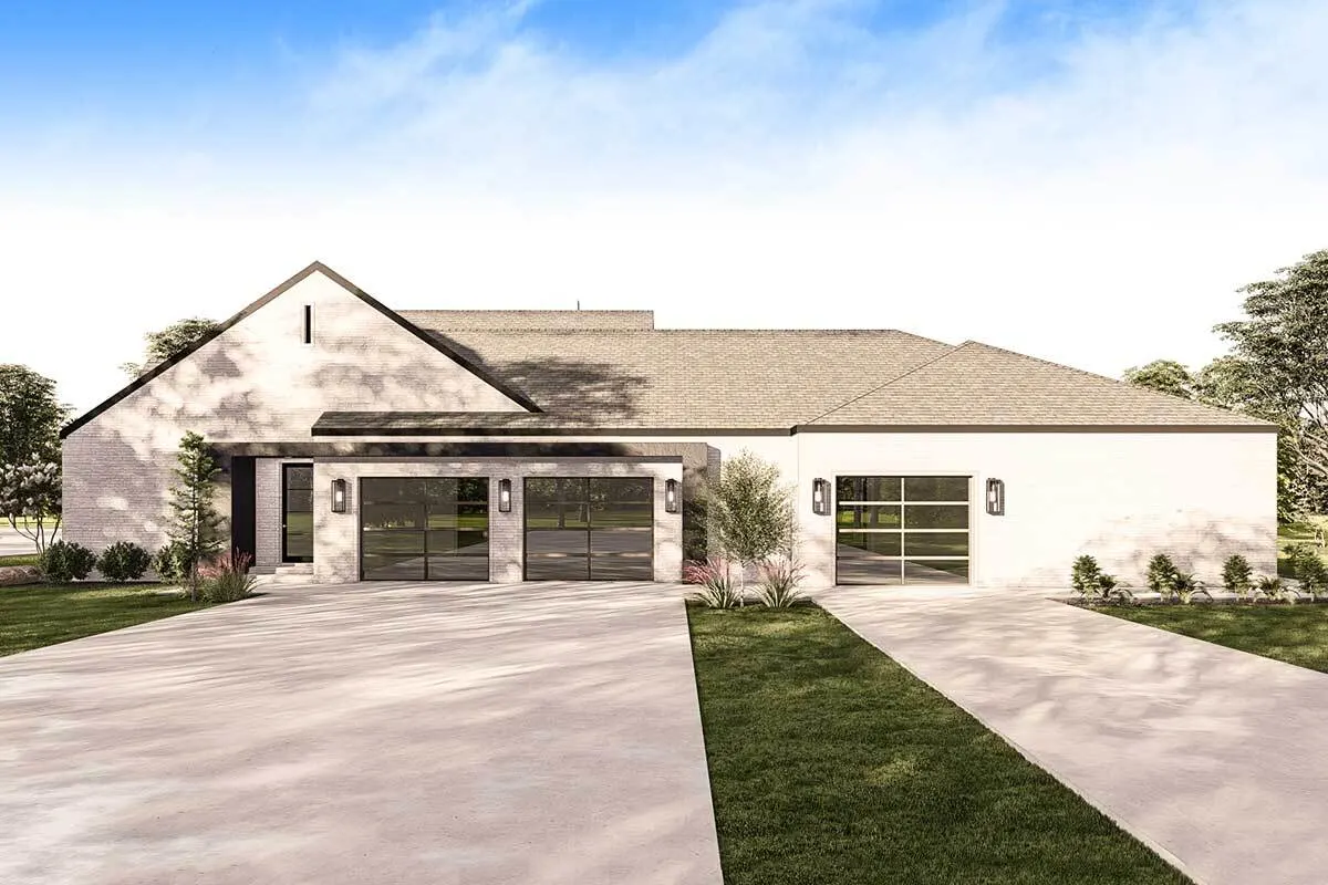 A large driveway and a garage with three glass doors frame.