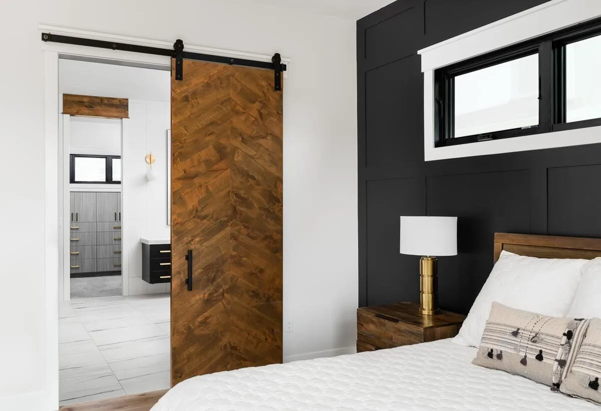 Sliding barn-style door in solid wood design access to the bathroom area.