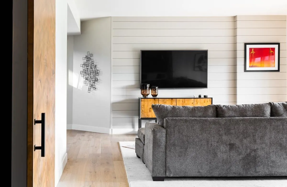 Recreational room area with gray sofa with television.