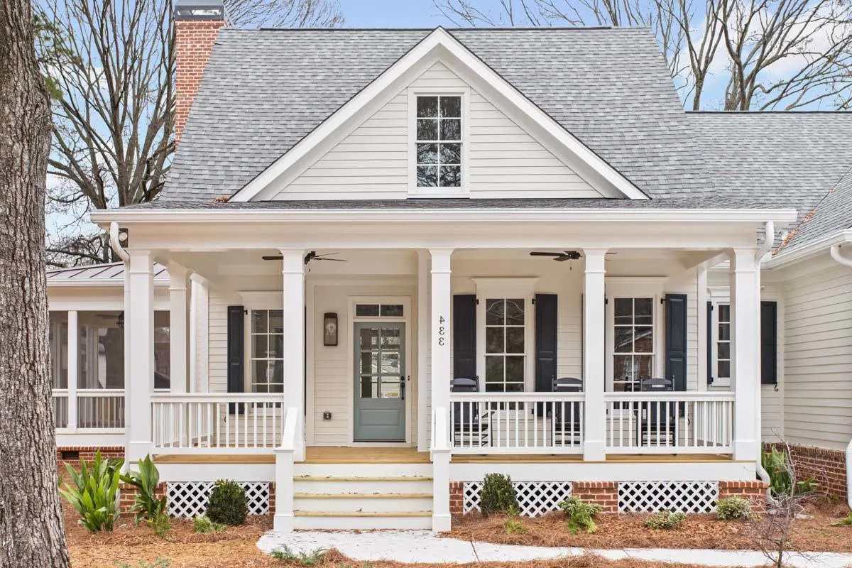 Wooden flooring and a light gray entry door may be found on the front porch.