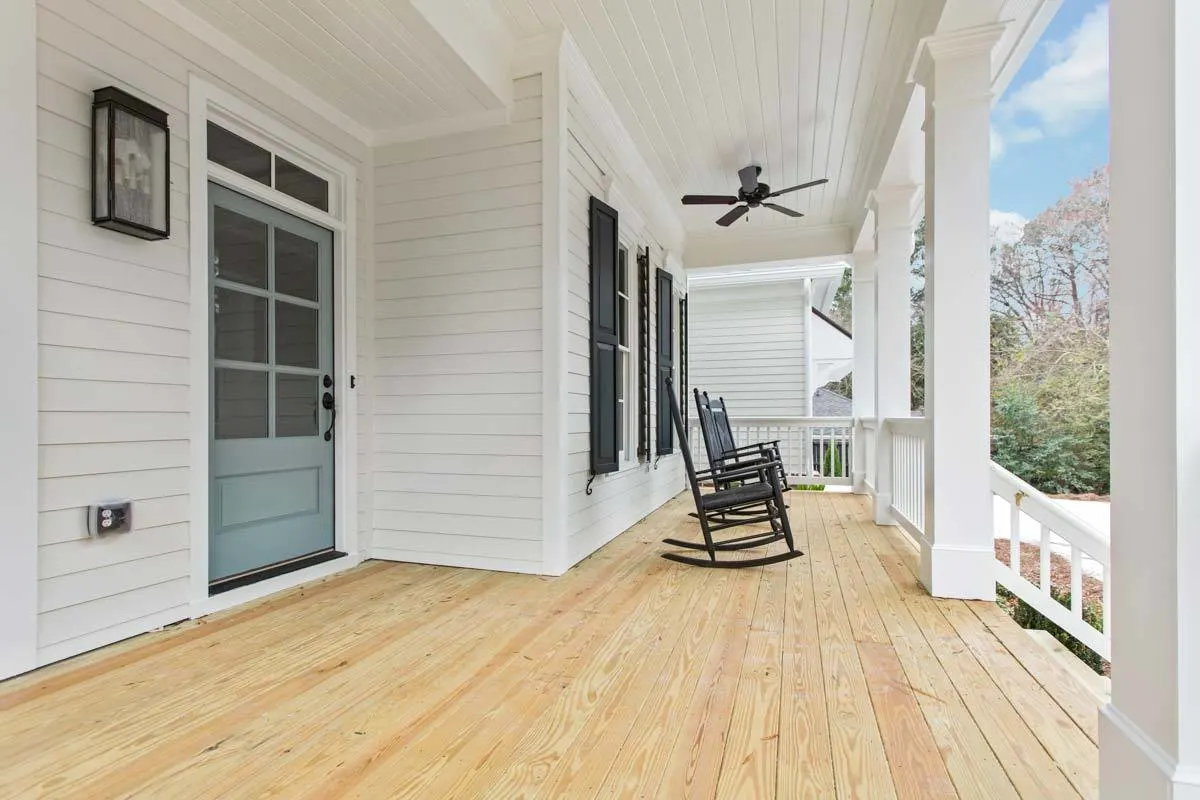The front porch area is attractive and is given color by the black shutters and rocking seats.