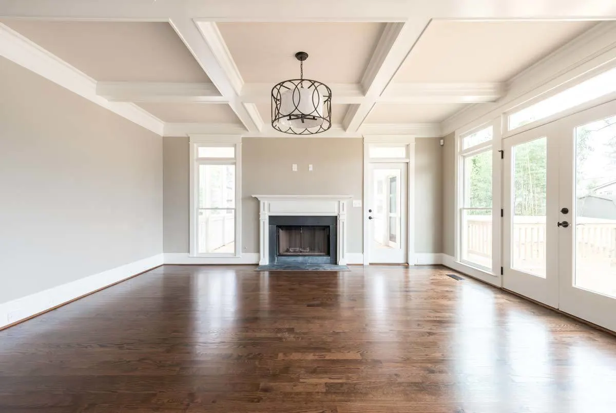 The room's focal point is a fireplace with a black frame.