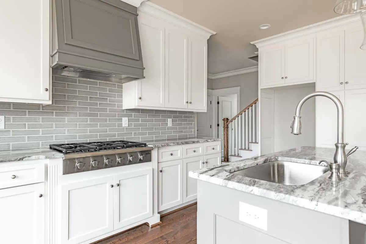 Placed prominently over the stove is a large gray range hood.