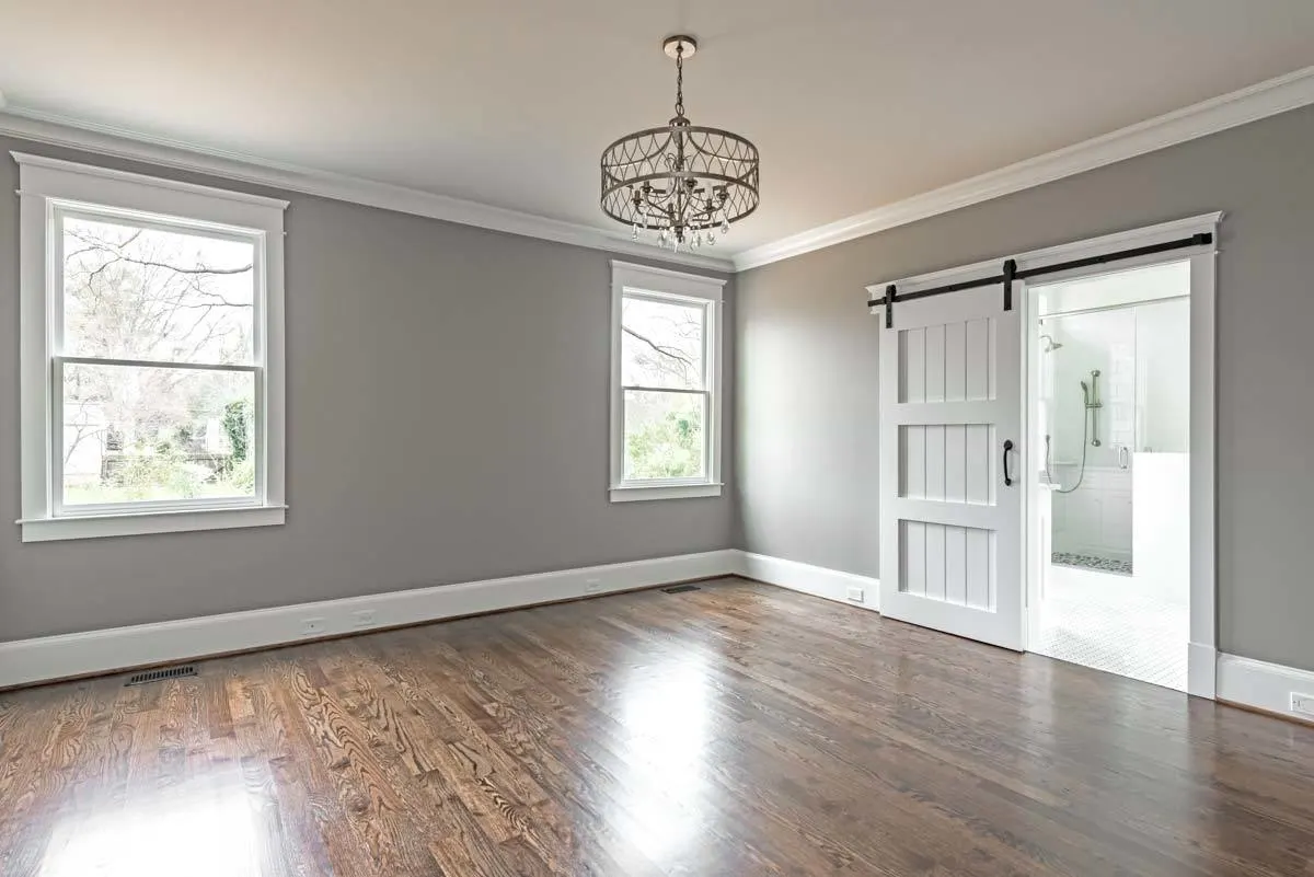 Master bedroom with sliding barn-style door and gray inside paint.