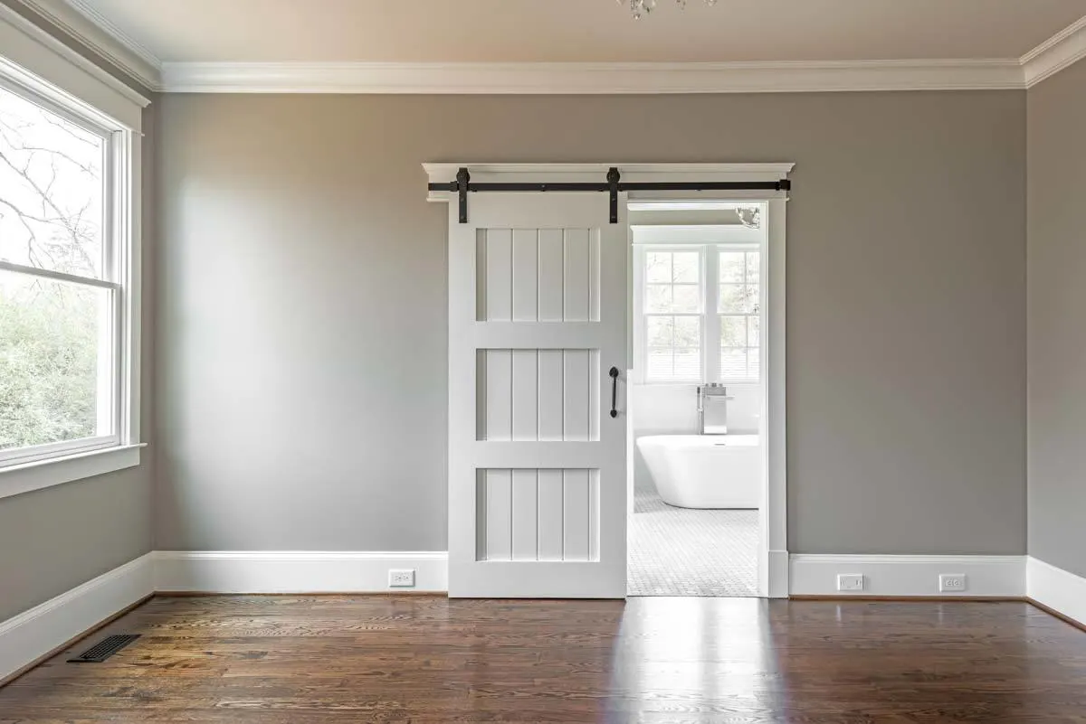 Master bedroom with gray inside paint and sliding barn door.