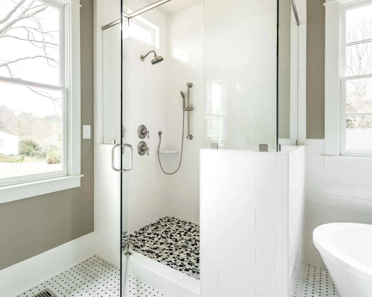 White brick walls and a glass window are features of the shower room.