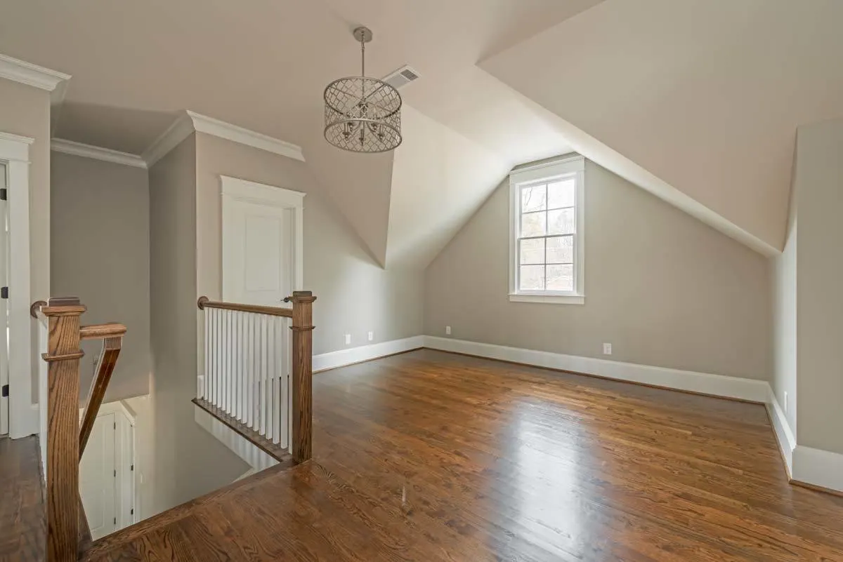 A wide corridor with wooden flooring on the second floor.
