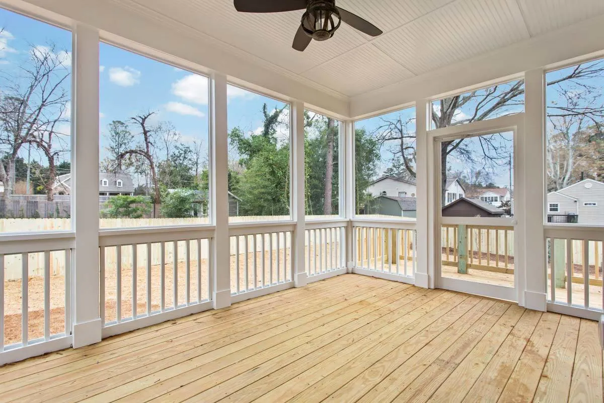 Screened porch area with white frame foundations and accent flooring made of wood.