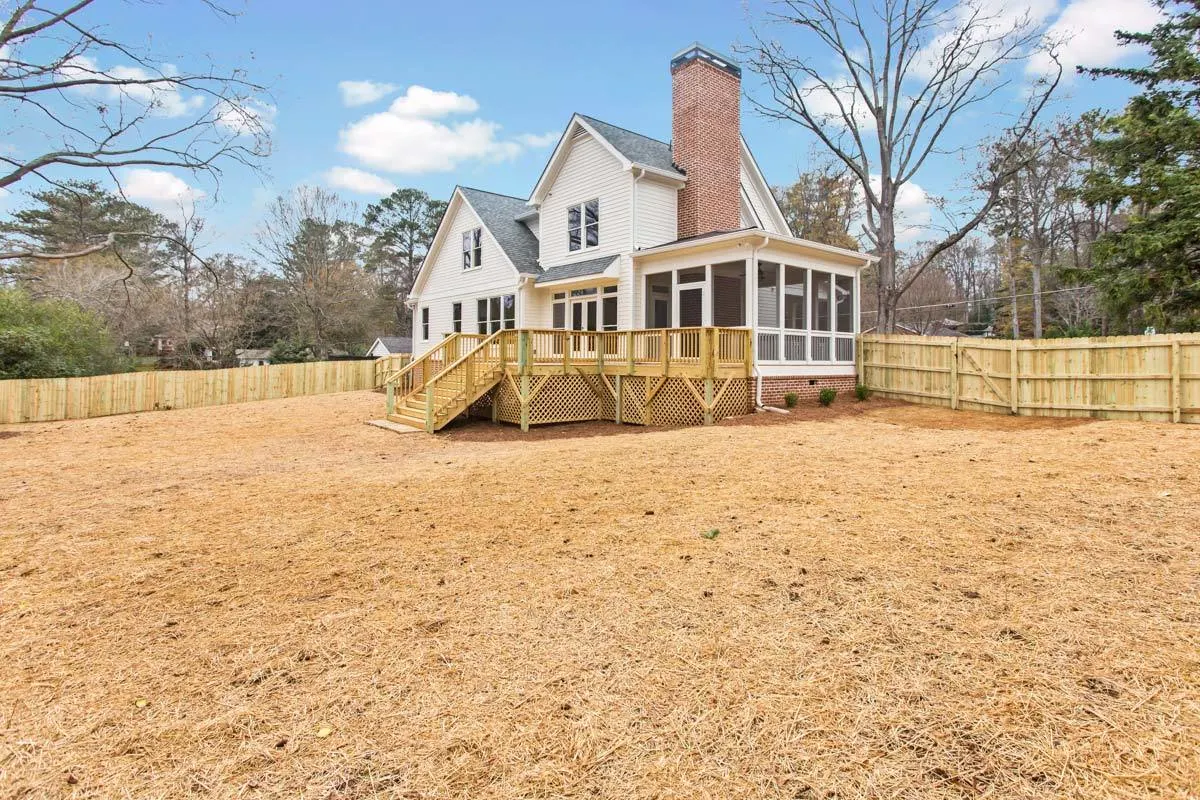 A spacious backyard leads to the screened porch via a wooden stairway.