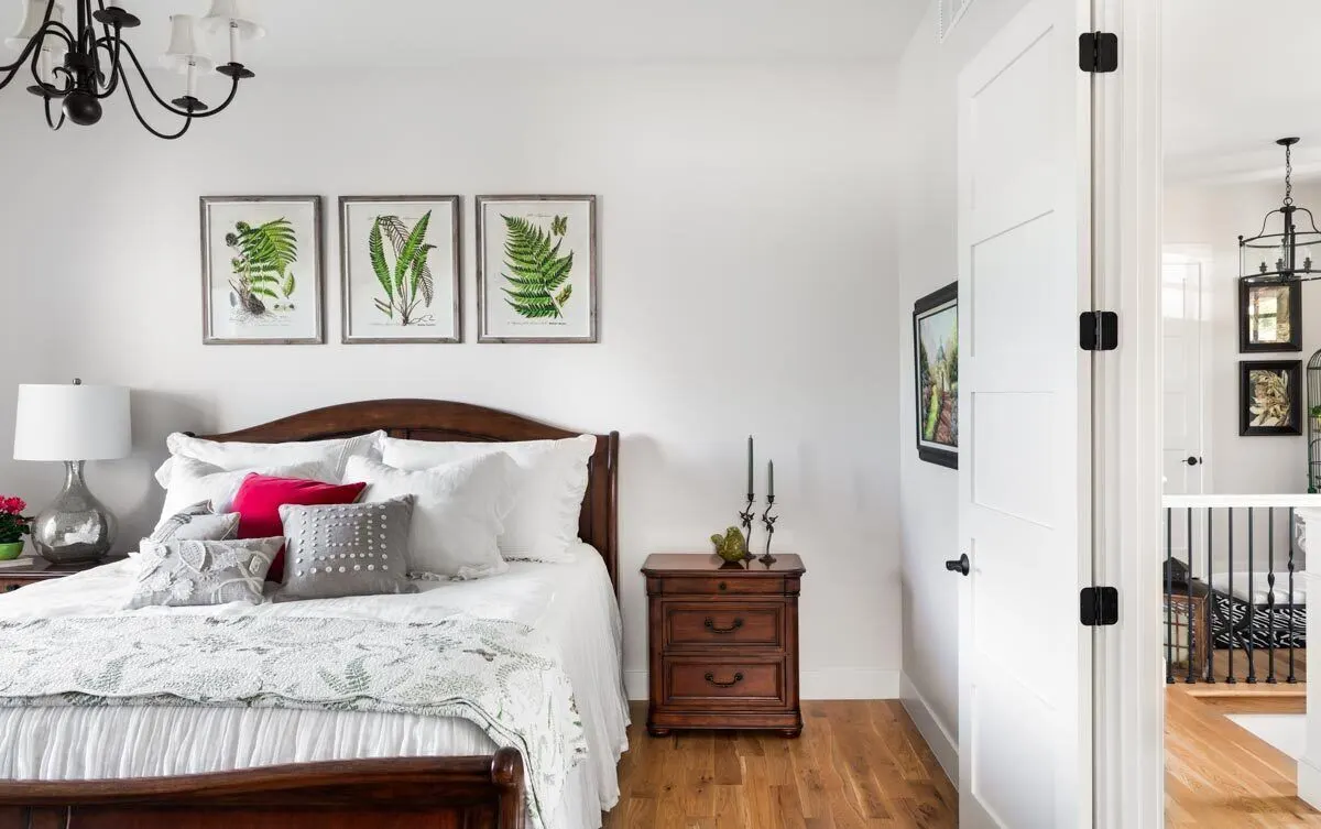 Wide bedroom space with a comfortable and warm ambiance, complete with a solid wood bed and side table.