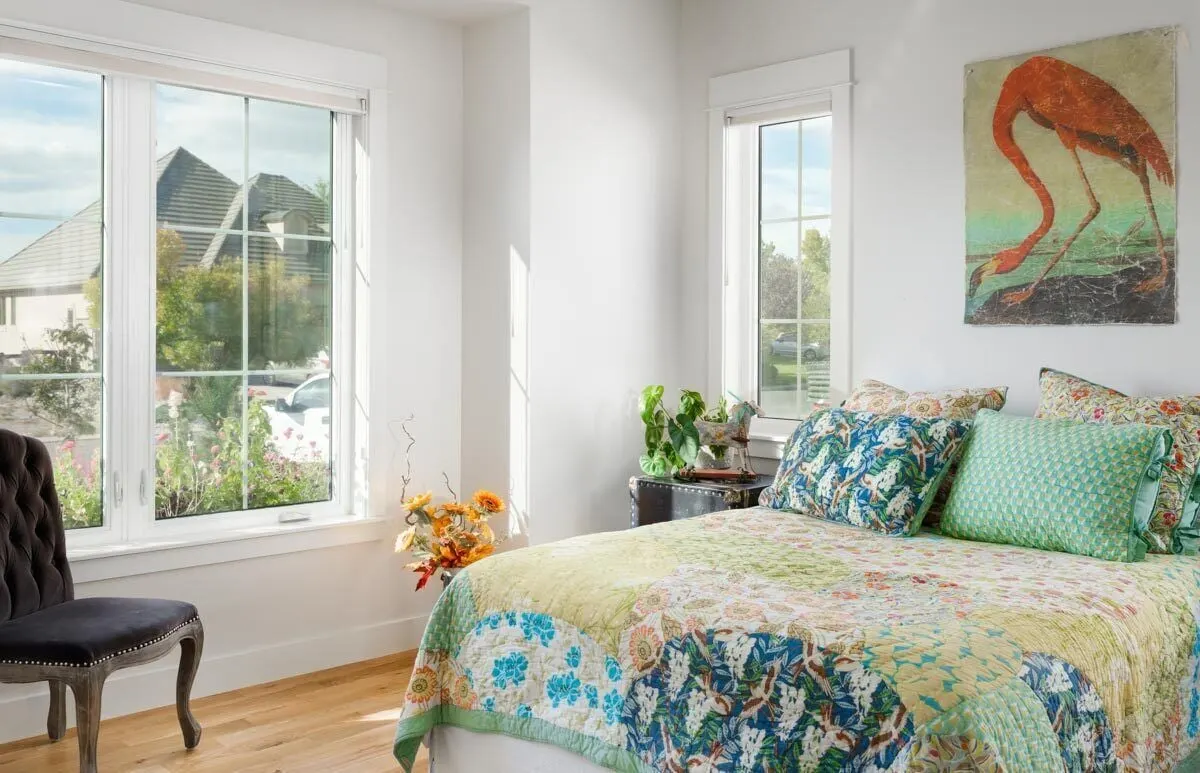 Another elegant bedroom with a view of the outside from the large windows.