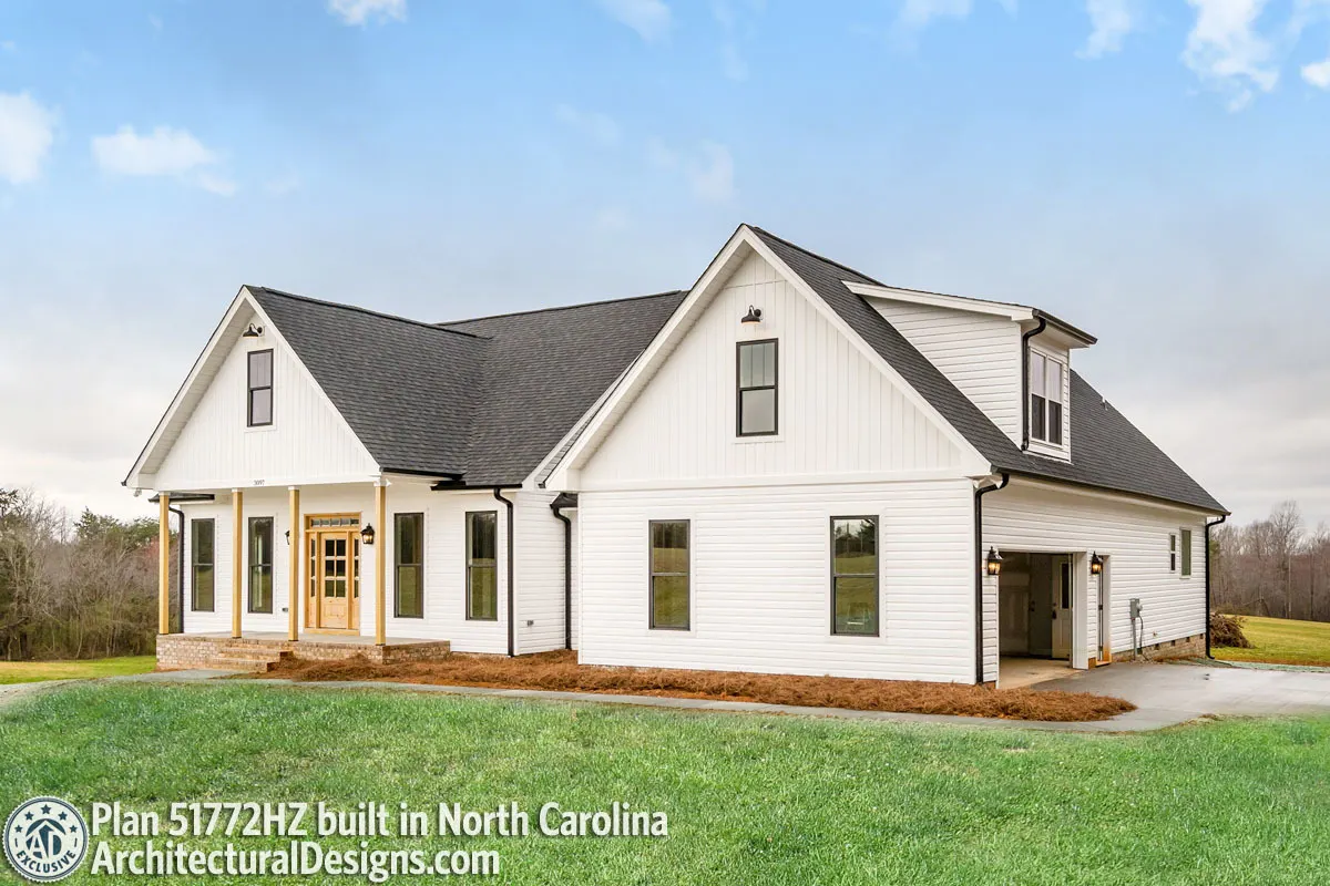 The modern farmhouse with a vaulted room and a garage on the side.
