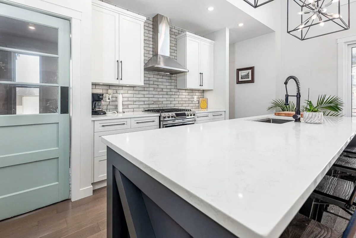 White marble center island with a gray foundation frame.