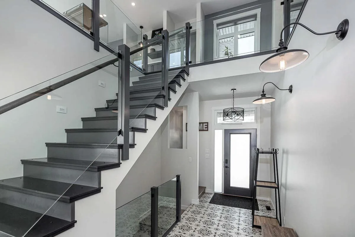 The foyer has a black-and-white color scheme with a stairway leading to the second floor.