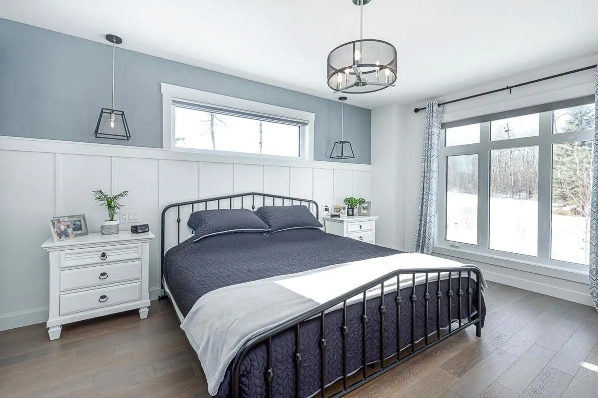 Bedroom with a stylish appearance and a big window overlooking the outside.