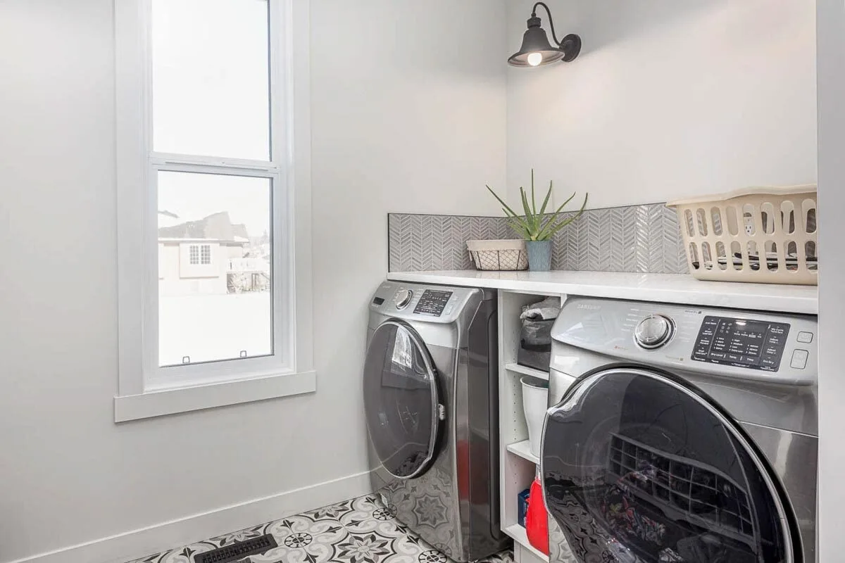 Laundry room with a black-and-white décor that matches the house interior.