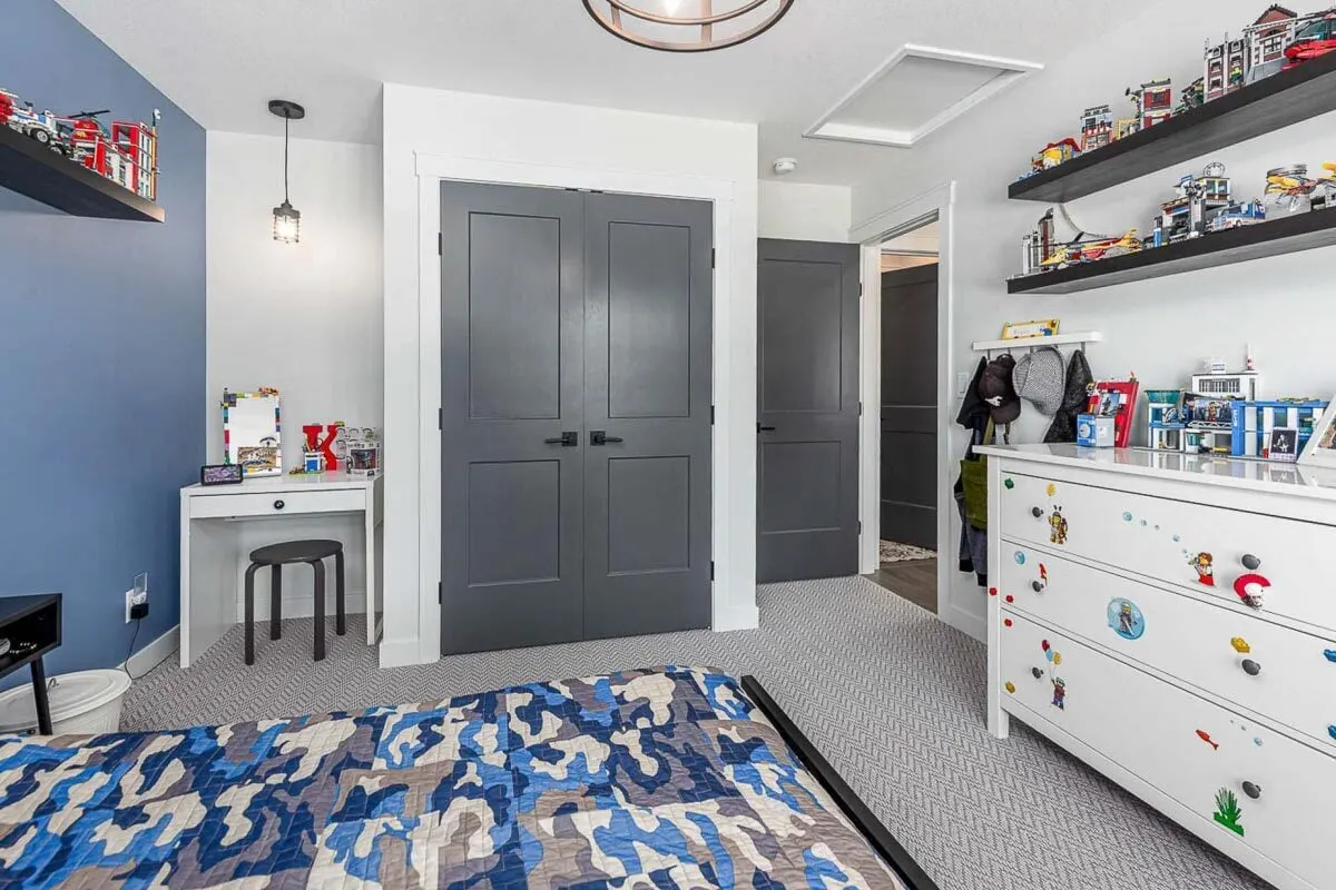A wall-mounted rack and a large white closet drawer are located in front of the bed.