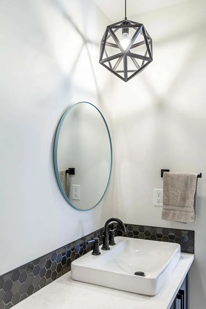 The geometric lighting decor on the vanity gives off a warm appearance.