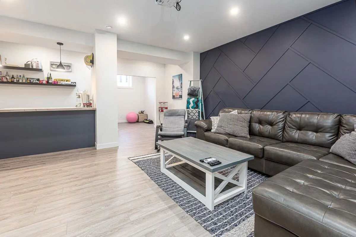 Basement family room area with comfy sofa in  L-shape design.