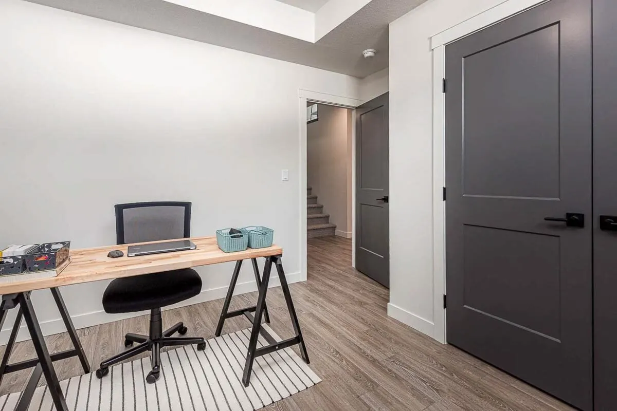 Workstation with a black office chair and a wooden accent table.