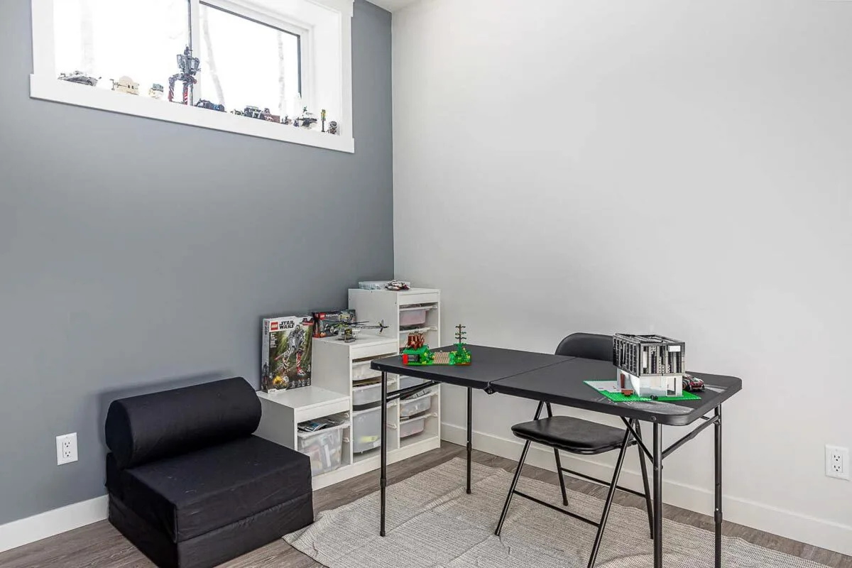 Room section with a work table and a toy rack.