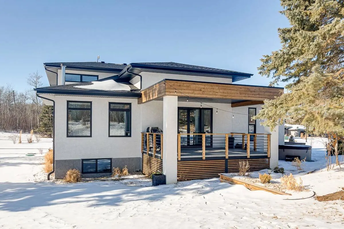 The covered deck is a wooden framework and is seen in the distant back picture of the home.