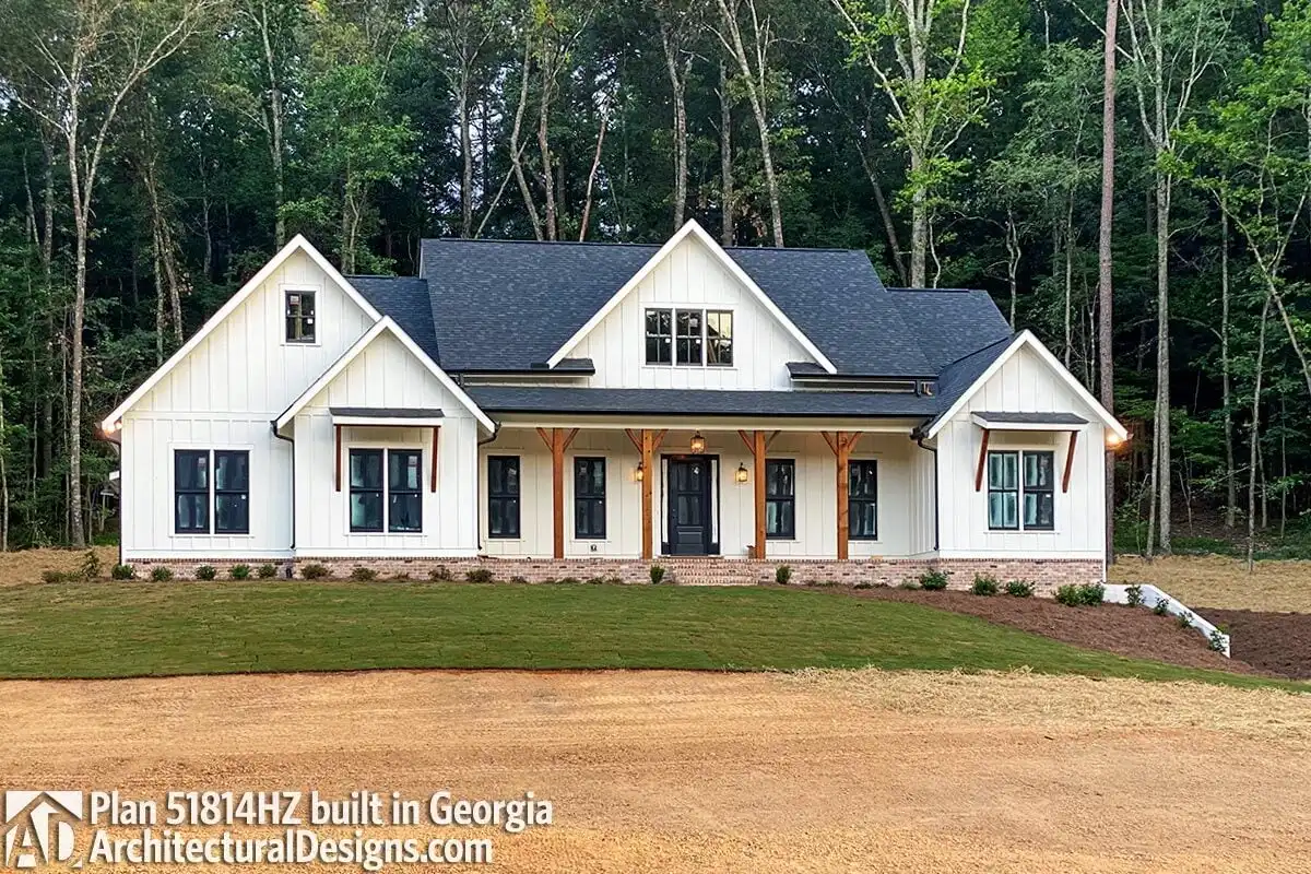 The front view of the house's dark blue and white color scheme reveals the wooden accent pillars of the porch.