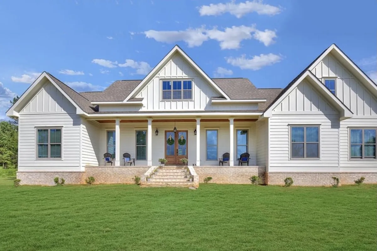 A view of the farmhouse that centers on a roomy porch and a French door.