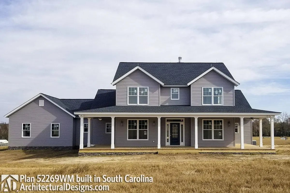 The farmhouse's lovely gray color and the porch's sophisticated use of wood flooring.