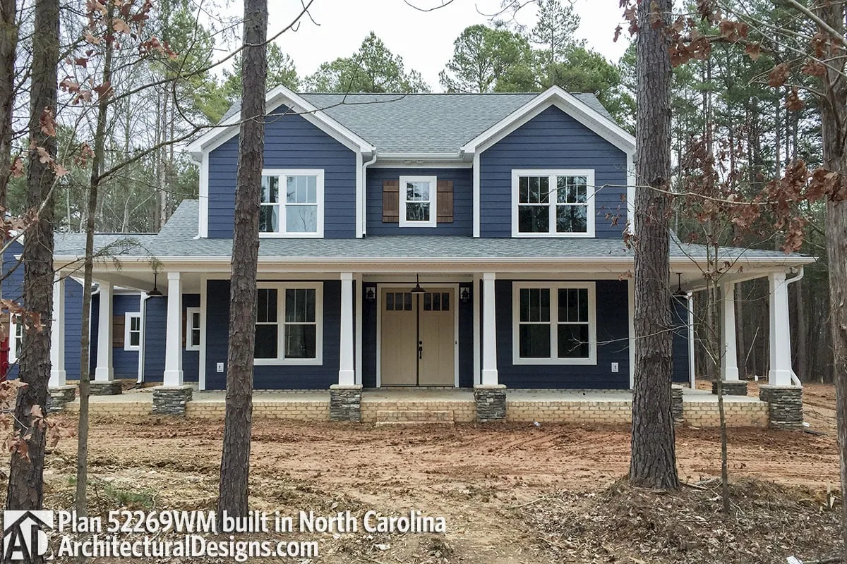 The wonderful dark blue of the farmhouse and the artful usage of brick lining on the porch.