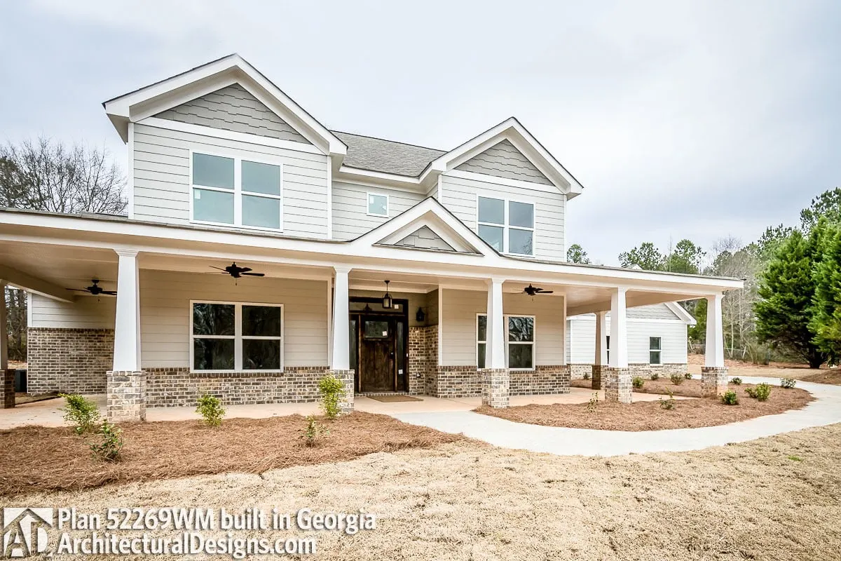 A farmhouse with a big, wide front yard was constructed in a bright tone design.
