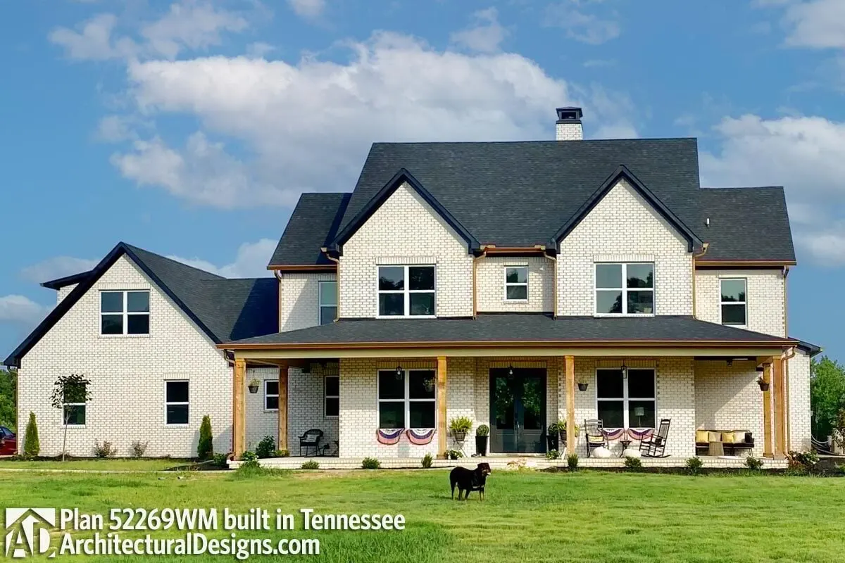A view of a country farmhouse with accent timber pillars and brick walls.