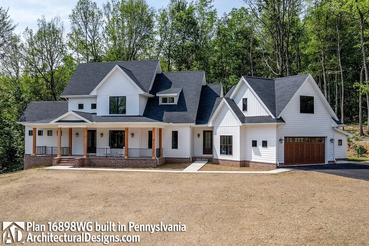 A traditional farmhouse style with a barn-type entrance in the garage.