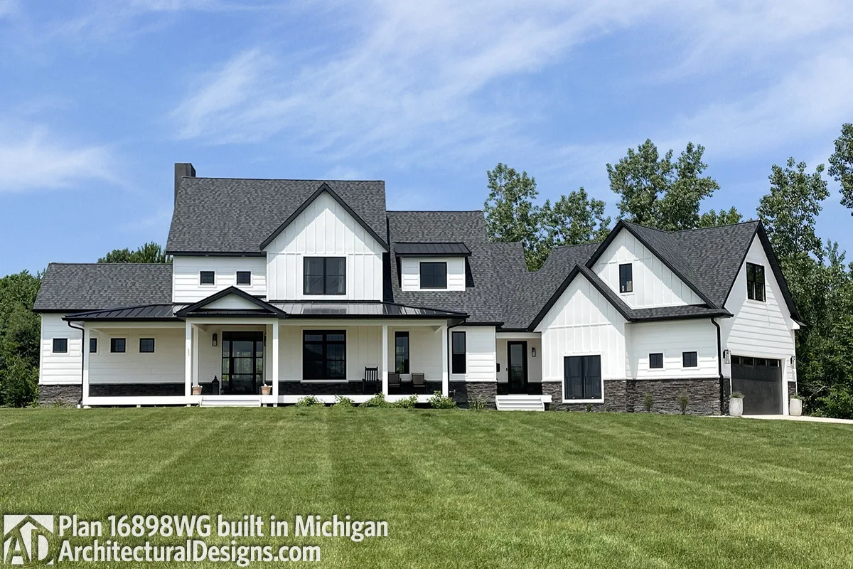 The black and white farmhouse looks stunning in the neatly cut green yard.