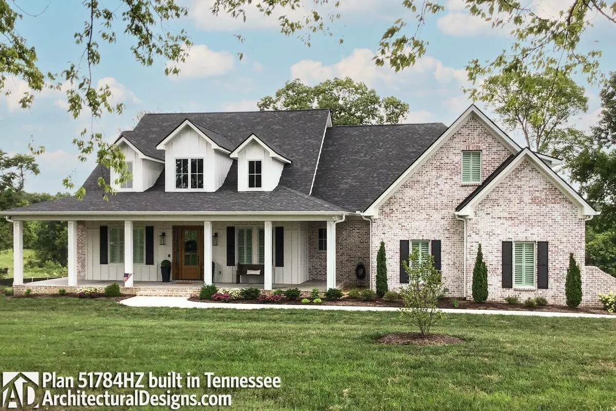 Farmhouse design with board and batten siding and brick accents.
