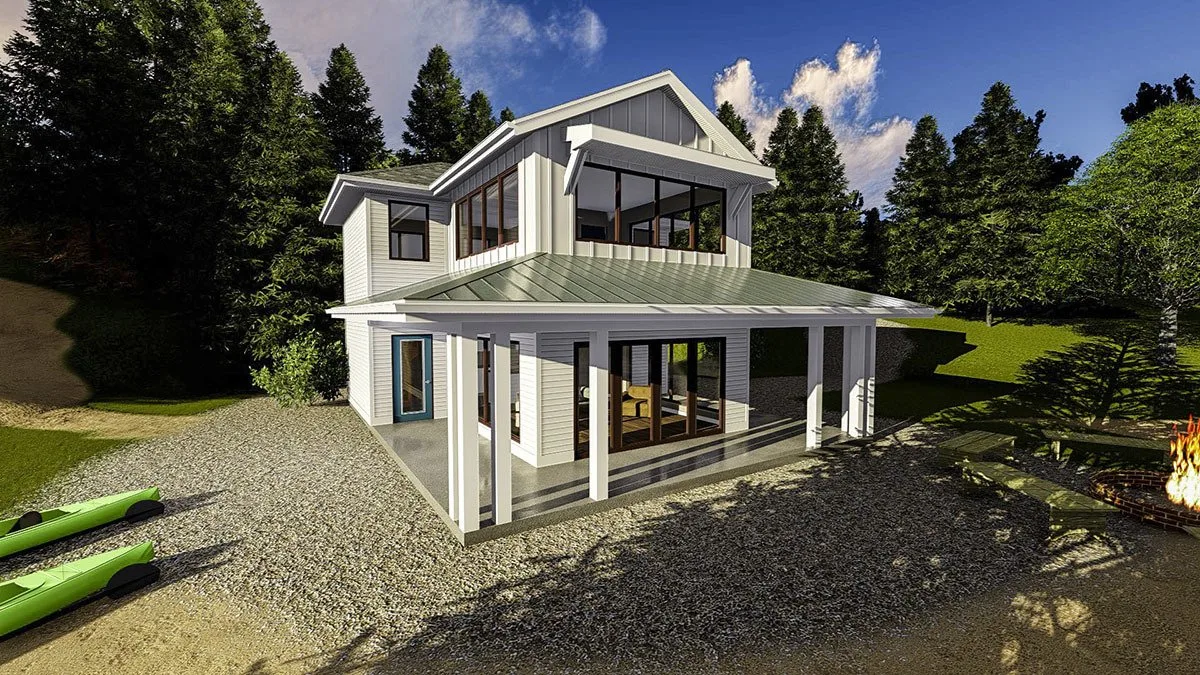 View from a distance of the vacation home with a green accent roof and a campfire on the side of the yard.
