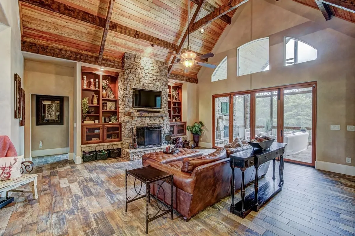 Living room with a stone frame fireplace in the middle.