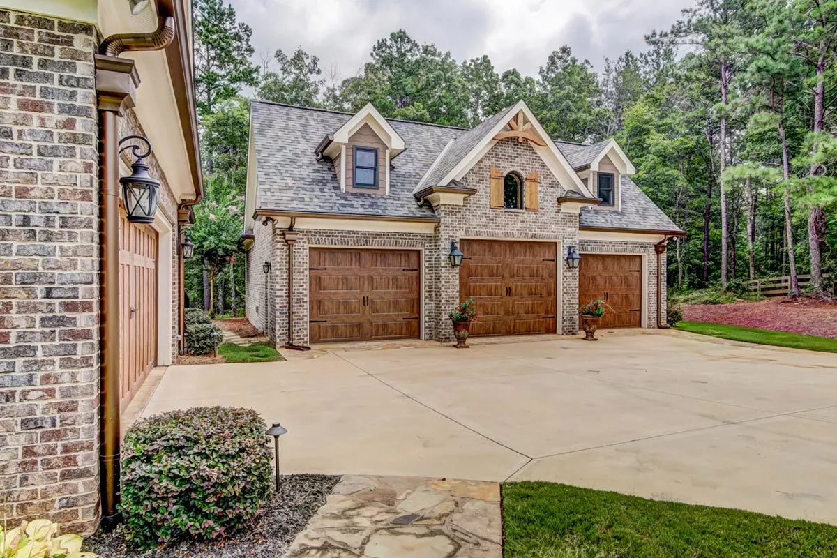 Detached garage area with three doors in wooden accent design.