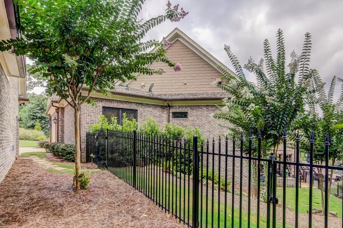 A black metal fence with a gate fits its purpose effectively.