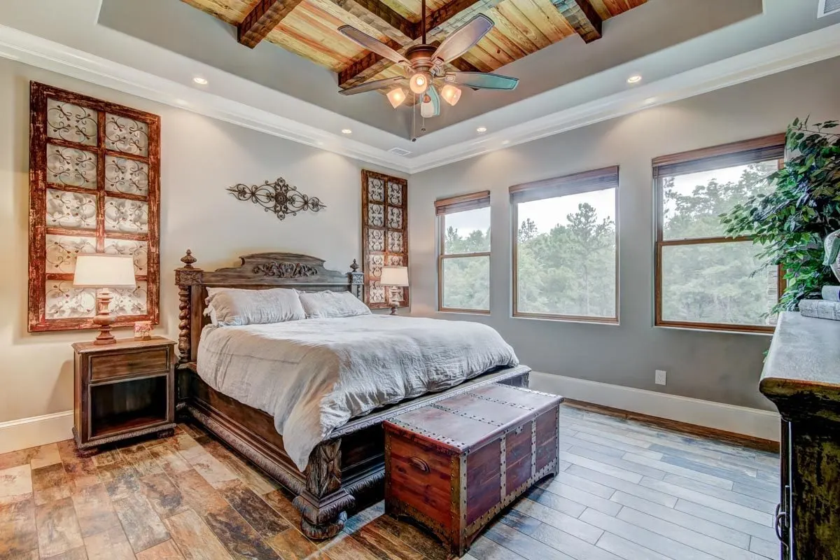 Natural light enters the bedroom through window glass in a wooden accent frame.