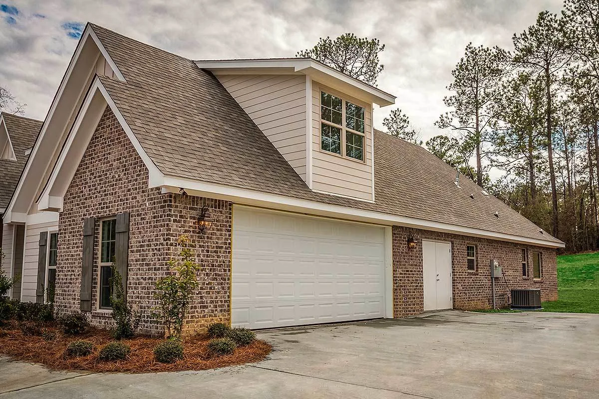 Garage with a large white door and a secondary entrance to the storage.