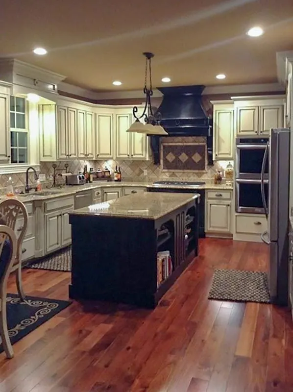 In the interior of the kitchen, a black island countertop and range hood stand out.