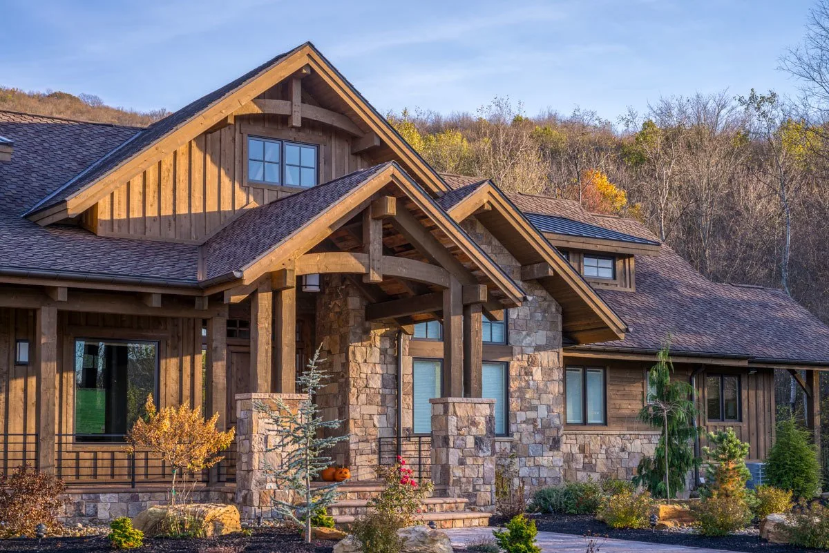 The front porch area of the house in a rustic style design looks great with the landscape.