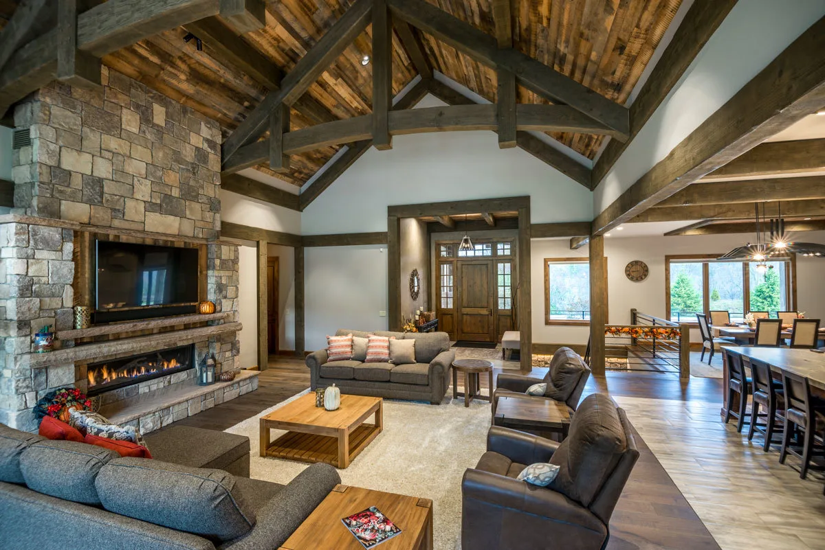 The great room space has a polished aesthetic thanks to the use of wooden accent framing from the ceiling to the windows.