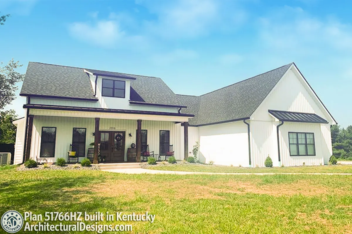 A nice-looking modern farmhouse with greenery yard and a wooden accent porch and French door.