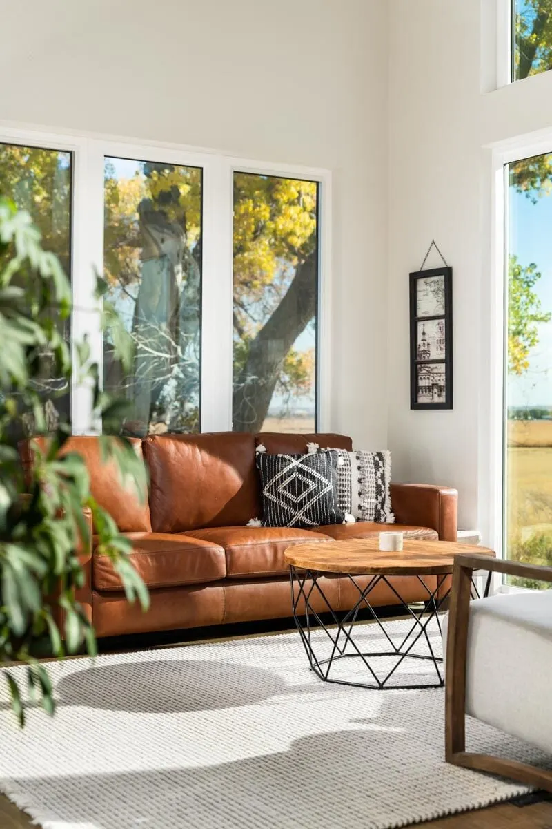 A comfortable living room with a carpet and wooden accent furniture look great together.