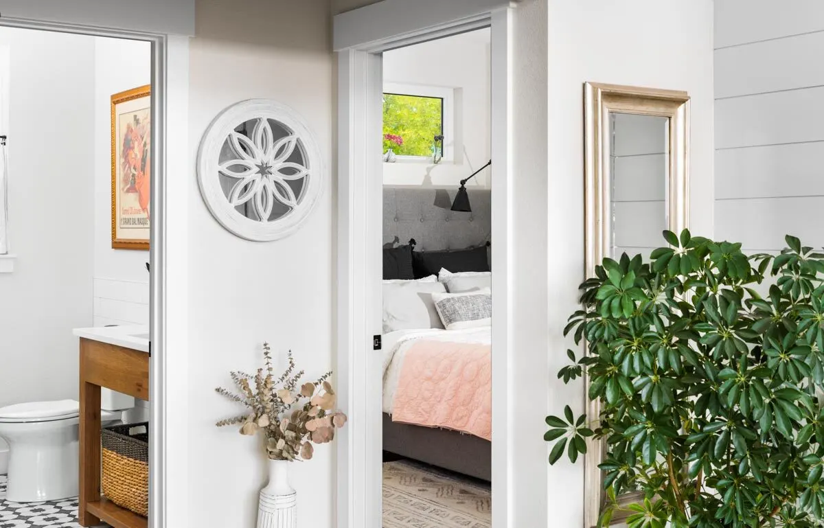A toilet adjacent to a bathroom with plants for decoration brings vitality to the room.